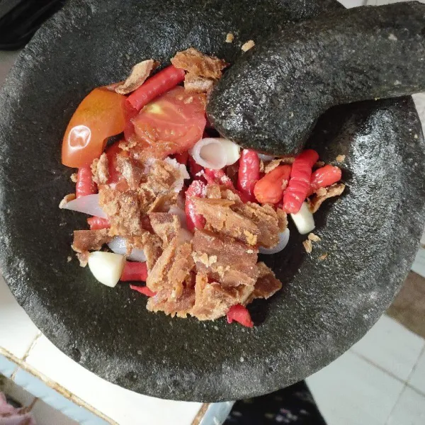 Rebus bawang, cabe dan tomat hingga matang, ulek hingga halus lalu tambahkan gula merah dan garam.