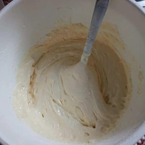 Masukkan sedikit demi sedikit tepung terigu yang sebelumnya diayak, sambil aduk adonan agar tercampur rata