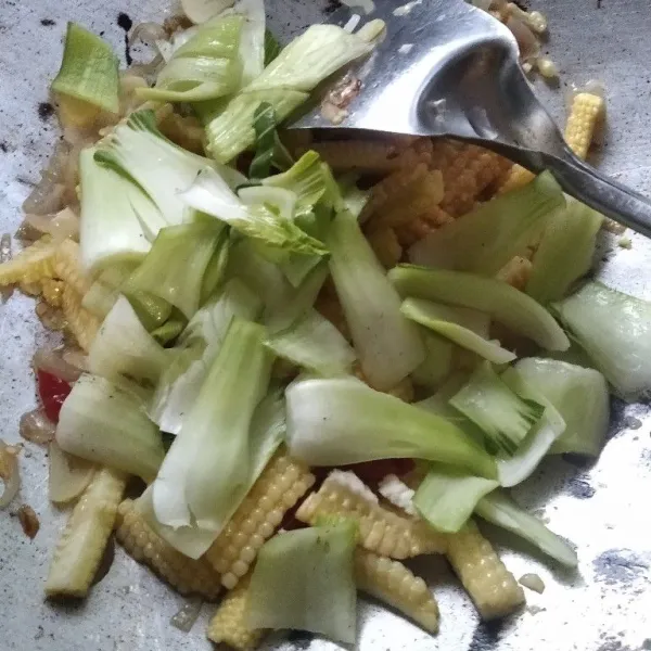 Masukkan bagian batang pokcoy, aduk rata hingga batang pokcoy mulai layu.