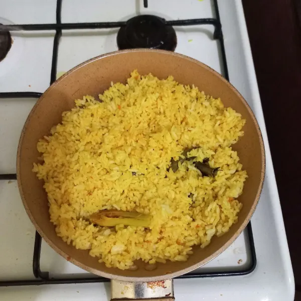 Beri garam dan kaldu jamur, aduk rata dan masak hingga nasi goreng matang.