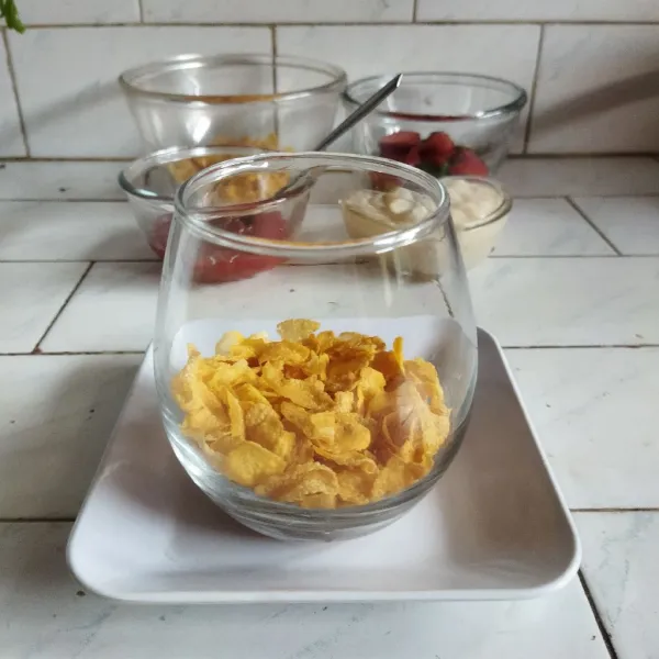Masukkan cornflake ke dalam gelas.