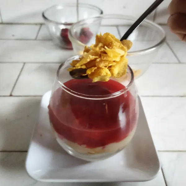 Tambahkan lagi sereal dan topping dengan buah strawberry. Masukkan dessert ke dalam lemari es minimal selama 2 jam untuk hasil yang maksimal.