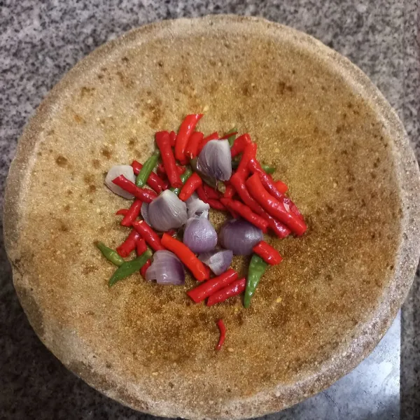 Tuang bahan sambal yang telah dikukus pada cobek, sisihkan.