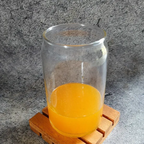 Siapkan gelas dan tuang sirup rasa jeruk.