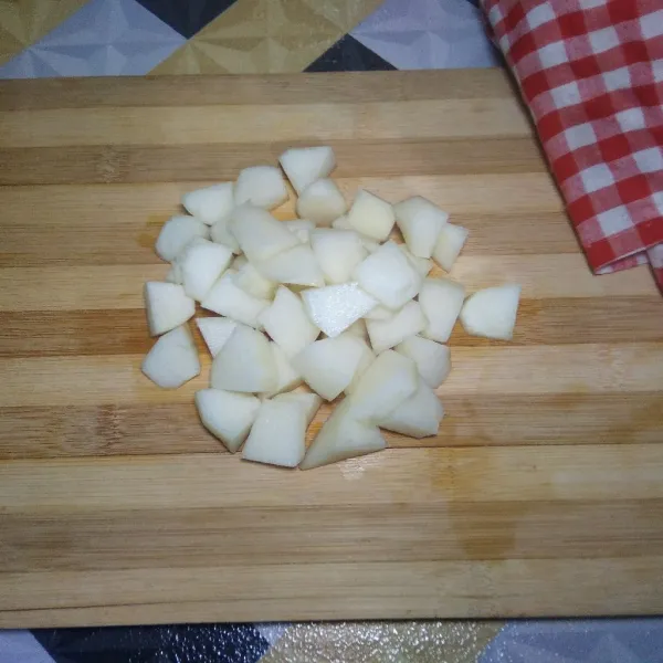 Potong buah pear menjadi bagian kecil.