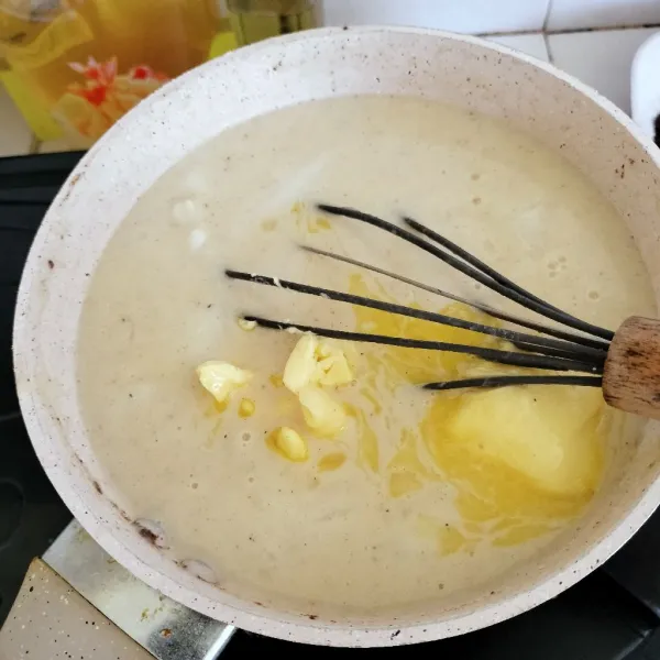 Masukkan kuning telur, lalu aduk cepat. Tambahkan margarin, aduk dan sisihkan.