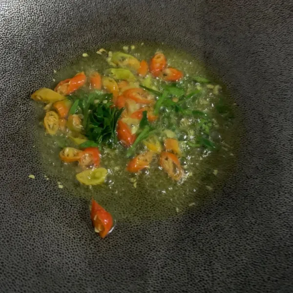 Potong cabe dan daun jeruk lalu campurkan ke dalam wajan.