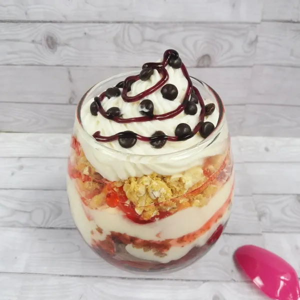 Semprotkan whipped cream, taburi chocochips, beri saus strawberry, dan sereal yogurt dessert siap dinikmati.