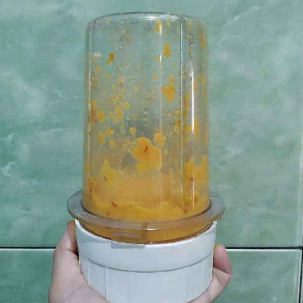 Masukkan bawang merah, bawang putih, cabe, kunyit bakar, kemiri dan 2 sdm minyak goreng ke dalam blender lalu haluskan semuanya.