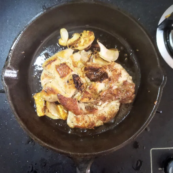 Jangan lupa untuk menyendokkan minyak bumbu ke atas ayam. Setelah ayam kecokelatan balik di sisi berikutnya, ulangi menyiram minyak bumbu di atas ayam.
