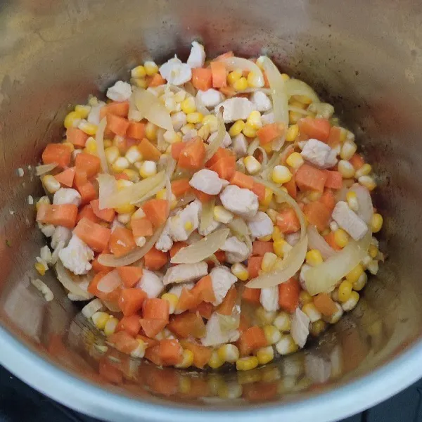 Tambahkan jagung dan wortel, tumis hingga sayur sedikit lembut.