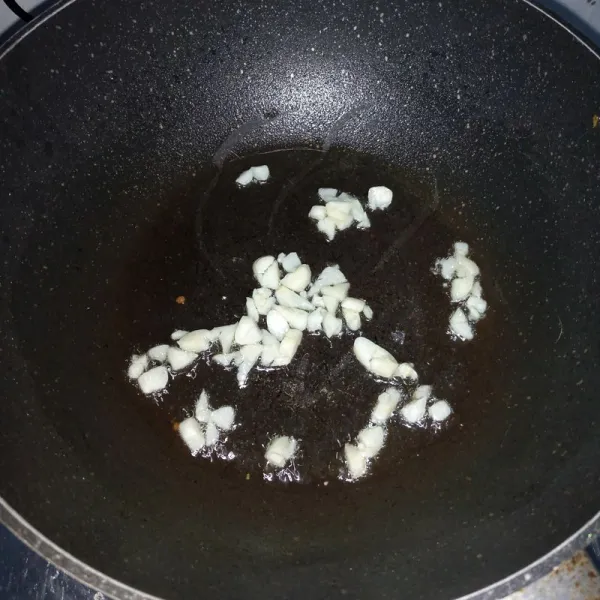 Tumis bawang putih sampai harum dan layu.
