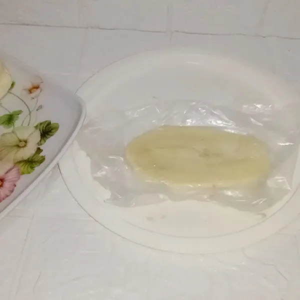 Alasi pisang dengan plastik kemudian penyetkan dengan piring.