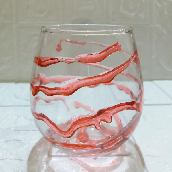 Beri saus strawberry di sekeliling dalam gelas saji.