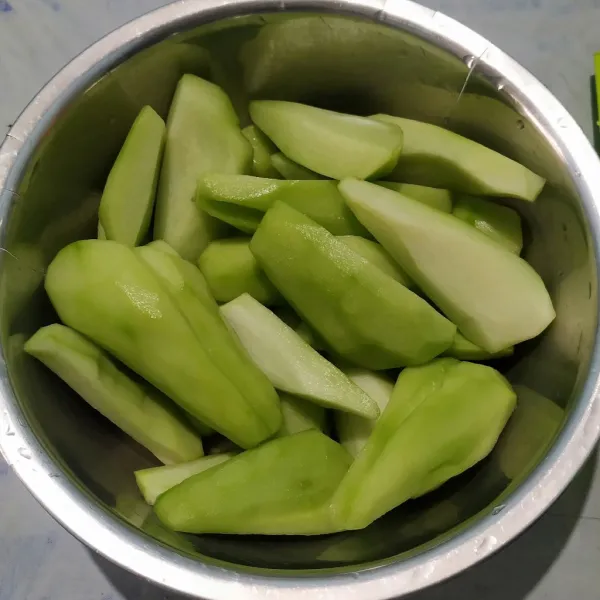 Kupas labu siam lalu cuci bersih. Serut labu siam berbentuk korek lalu rendam di air garam untuk menghilangkan getahnya selama 10 menit. Sisihkan.