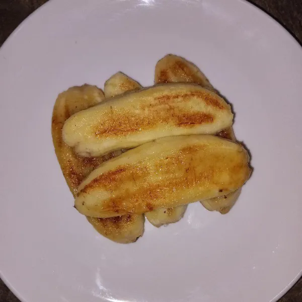 Tata pisang diatas piring lalu siram dengan kuah kinca.