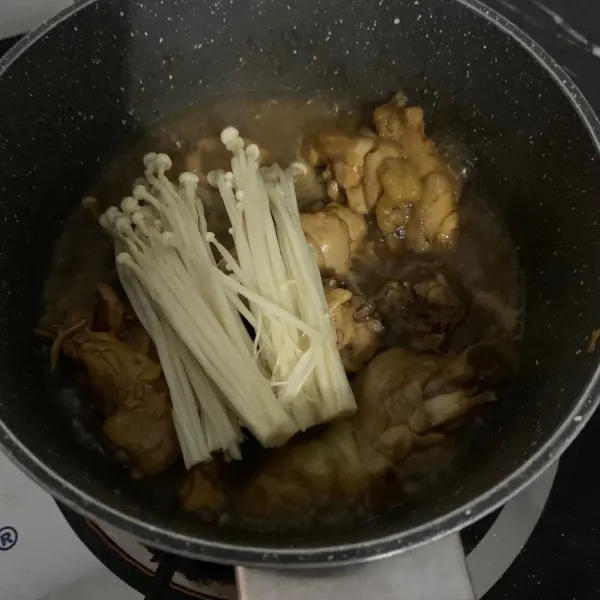 Potong bagian pangkal jamur dan campurkan ke dalam panci.