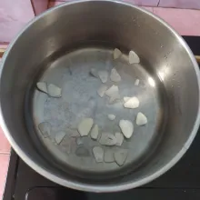 Rebus air, masukkan irisan bawang putih.