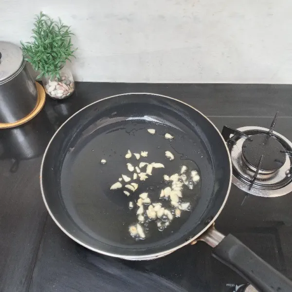 Panaskan 3 sdm minyak, tumis bawang putih hingga layu.