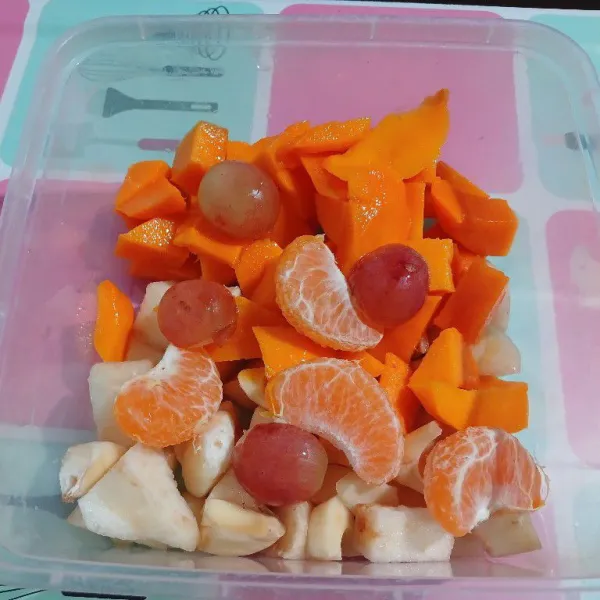 Kupas dan potong-potong dadu mangga, pear, apel, belah 2 anggur, tempatkan dalam 1 wadah, sisihkan
