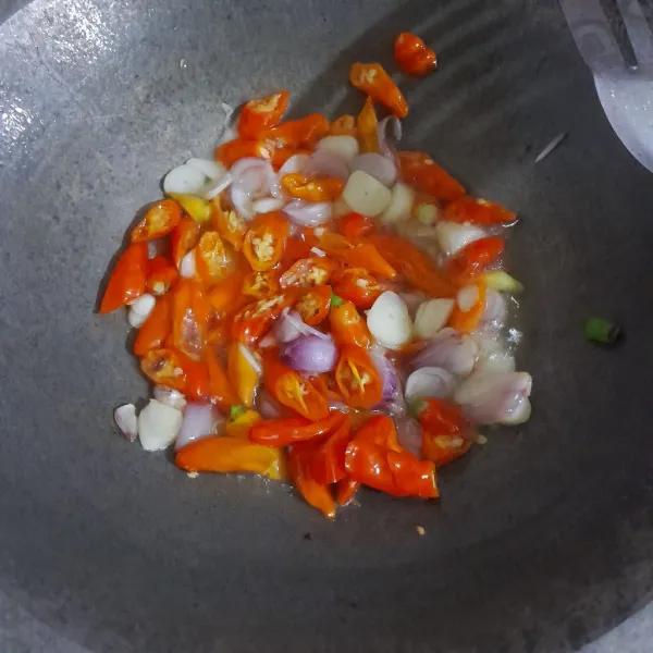 Panaskan minyak sayur dengan api sedang, tumis bawang merah, bawang putih, cabe rawit merah besar hingga layu.