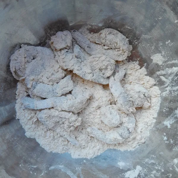 Ambil secukupnya udang yang sudah di marinasi, masukkan ke dalam wadah berisi tepung. Balut hingga semua bagian udang tertutupi tepung lalu angkat.