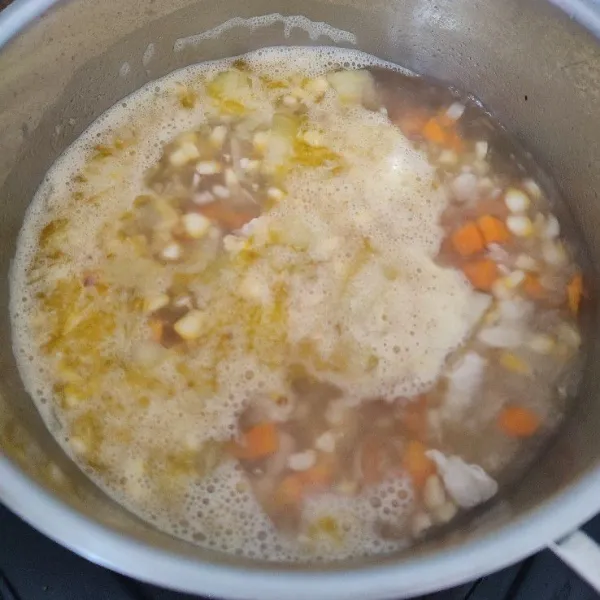 Tuang air, lada bubuk, garam dan kaldu jamur. Masak hingga air mendidih. Tambahkan jagung dan wortel, masak hingga sayur setengah mateng.