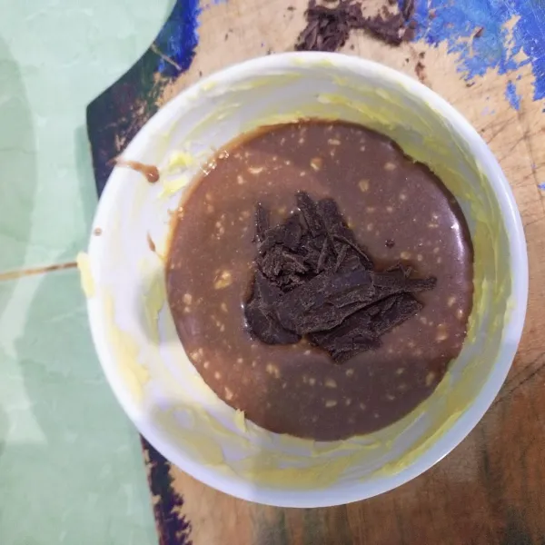 Siapkan wadah yang akan dibuat untuk mengukus, baluri dengan margarin wadahnya. Masukkan adonan dan beri cokelat batangan di tengah adonan.