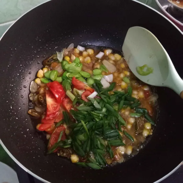 Masukkan petai, tomat hijau dan tomat merah serta daun bawang.