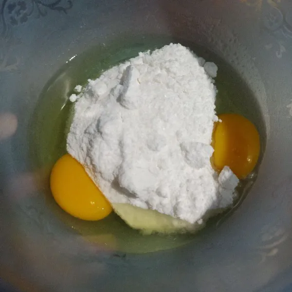 Campur di wadah bersih, dua butir telur dan gula halus. Kocok perlahan
