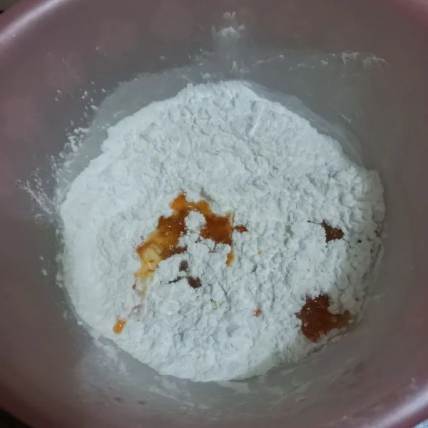 Tuang sedikit demi sedikit air larutan cabe pada campuran tepung tapioka.