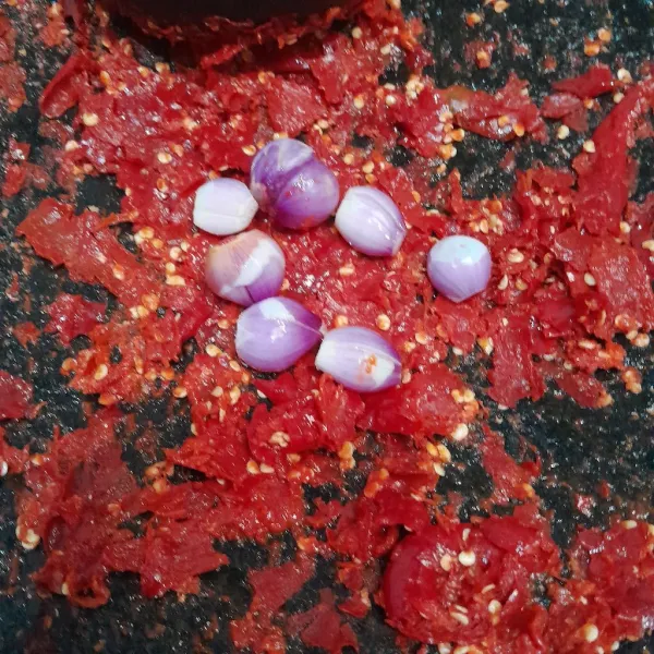 Giling cabai merah, lalu tambahkan bawang merah. Giling sampai halus.