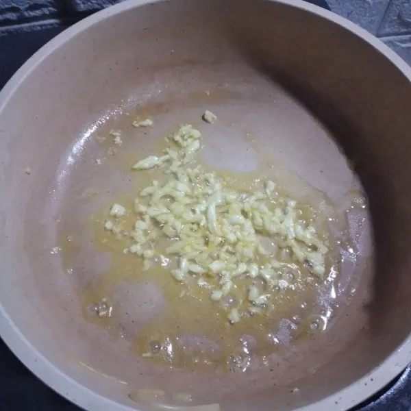 Geprek lalu cincang bawang putih, tumis di wajan teflon dengan minyak panas.