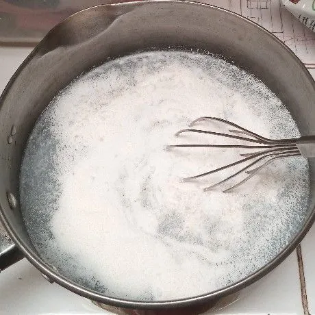 Campurkan agar-agar, gula pasir, santan, dan kental manis putih ke dalam panci. Aduk-aduk hingga tercampur rata.