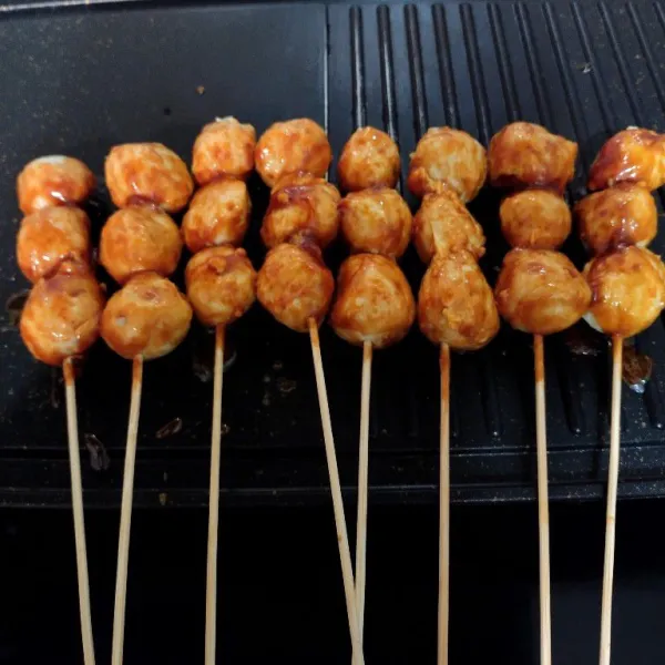 Panggang bakso sambil di oles dengan bumbu marinasi.
