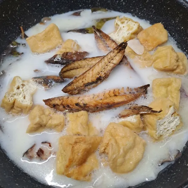 Masukkan potongan tahu goreng dan ikan pindang goreng, siram kuah sampai rata.