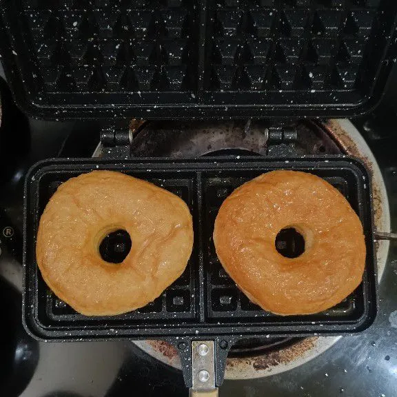 Panaskan teflon waffle, oles tipis margarin, letakkan donat glace ke teflon waffle, lalu panggang hingga matang, panggang sekitar 2 menit setiap sisi, gunakan api kecil.