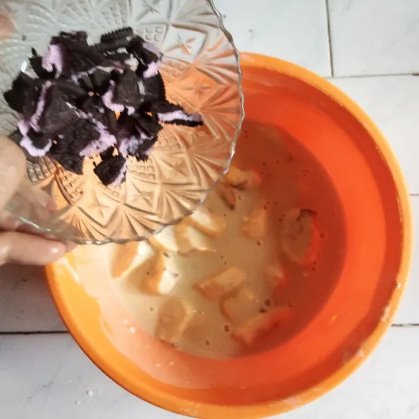 Tambahkan pisang, dan biskuit cokelat, aduk hingga rata tertutup adonan tepung.