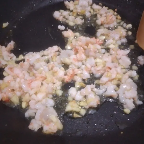 Masukkan udang cincang tumis bersama margarin dan bawang putih hingga berubah warna.
