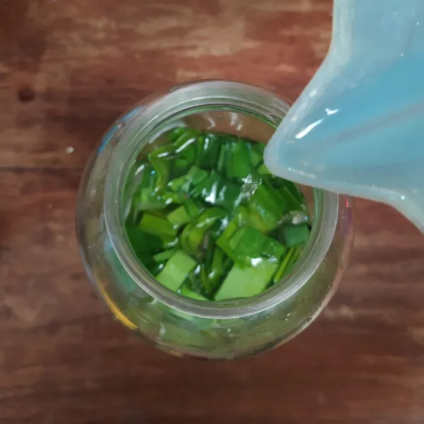 Potong-potong daun suji dan daun pandan. Masukkan ke dalam blender, tuang air.