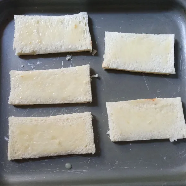 Pindahkan ke loyang dengan bagian yang dioles margarin menghadap ke bawah. Bagian yang di atas oles dengan kental manis secukupnya.