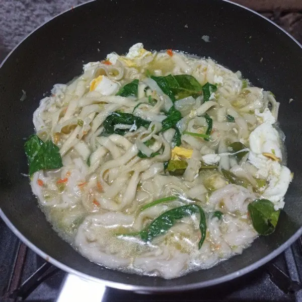 Masukkan kwetiau, kerupuk dan kangkung, aduk rata, koreksi rasa.