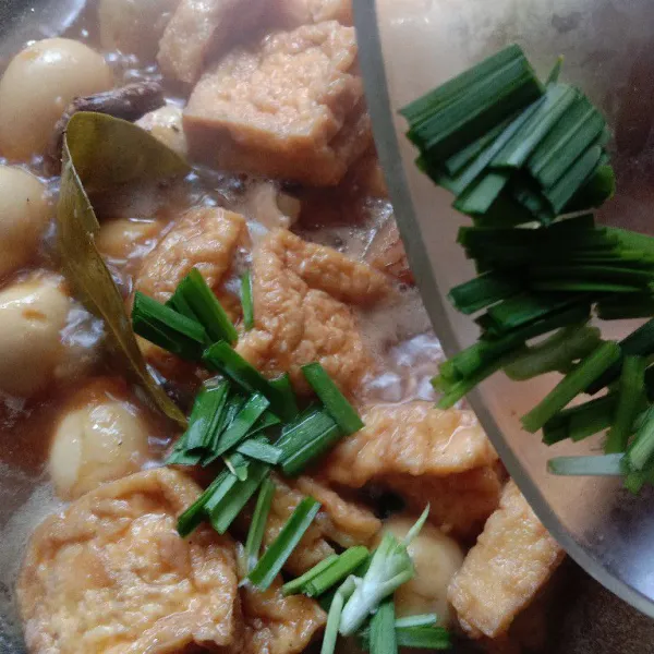 Jika kuah sudah mulai menyusut, koreksi rasa, jika dirasa sesuai, masukkan potongan daun kucai, aduk hingga kucai layu, matikan api dan siap disajikan.