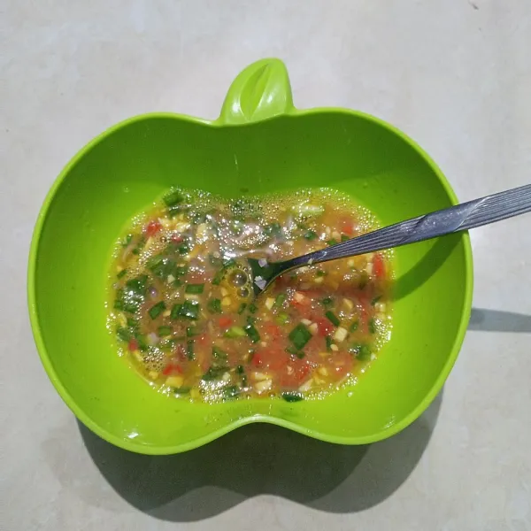 Masukkan irisan daun bawang, cabai, bawang merah, dan bawang putih kemudian kocok.