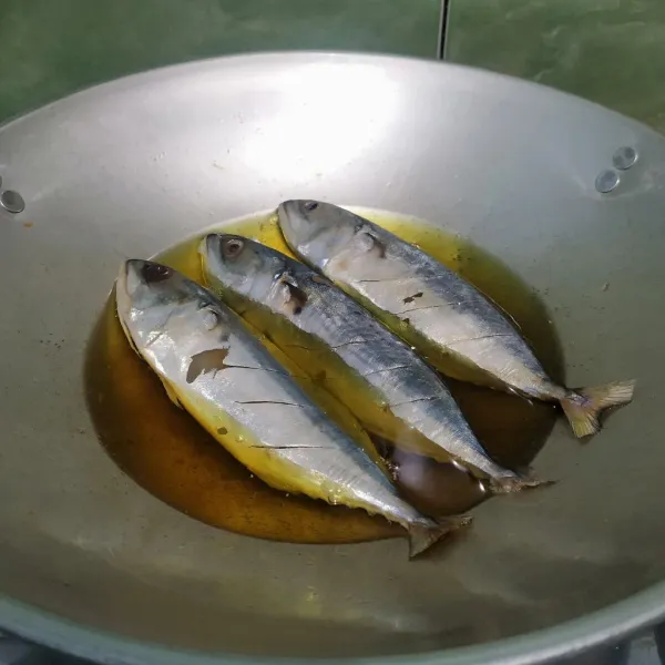Cuci bersih ikan kembung lalu beri perasan jeruk nipis, diamkan selama 5 menit. Bilas ikan dengan air matang lalu beri garam. Goreng ikan hingga matang. Sisihkan.