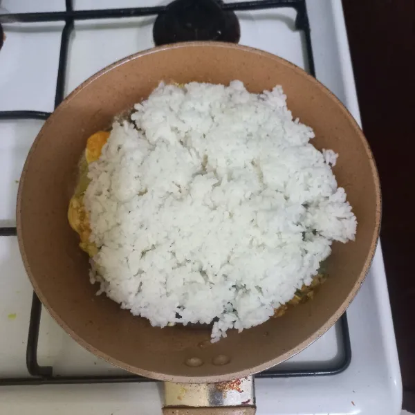 Masukkan nasi pada wajan, aduk rata.