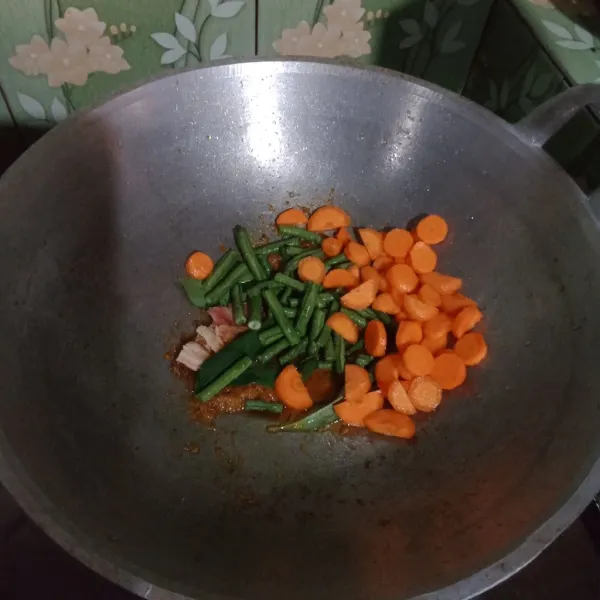 Masukkan kacang panjang dan wortel, tambahkan air dan masak hingga sayuran agak lunak.