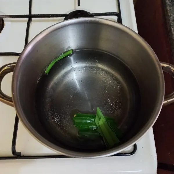 Didihkan air pada panci bersama potongan daun pandan.