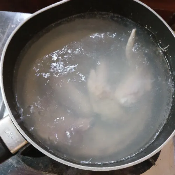 Didihkan air, masukkan sayap ayam. Rebus hingga empuk.