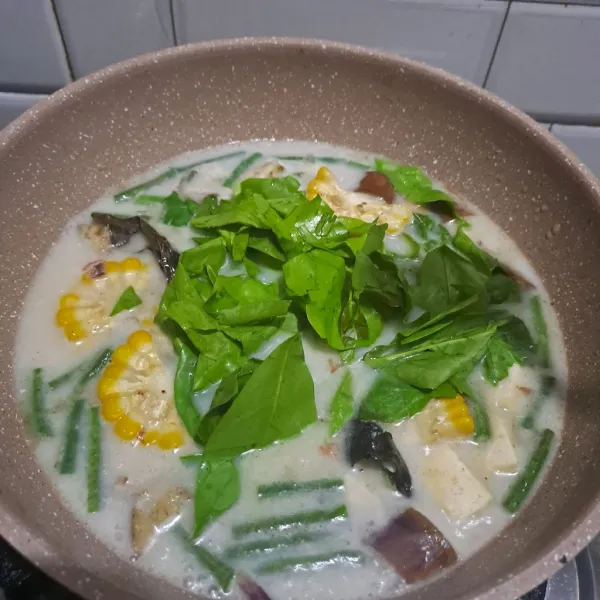 Masukan bumbu aduk rata, setelah sayur lain empuk lalu masukan daun belinjo.